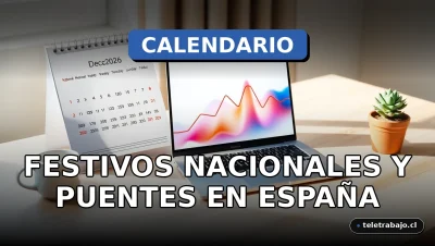 Calendario de escritorio 2026 abierto en el mes de diciembre, mostrando días festivos marcados en rojo, junto a un portátil y una taza de café en una oficina moderna.