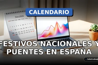 Calendario de escritorio 2026 abierto en el mes de diciembre, mostrando días festivos marcados en rojo, junto a un portátil y una taza de café en una oficina moderna.